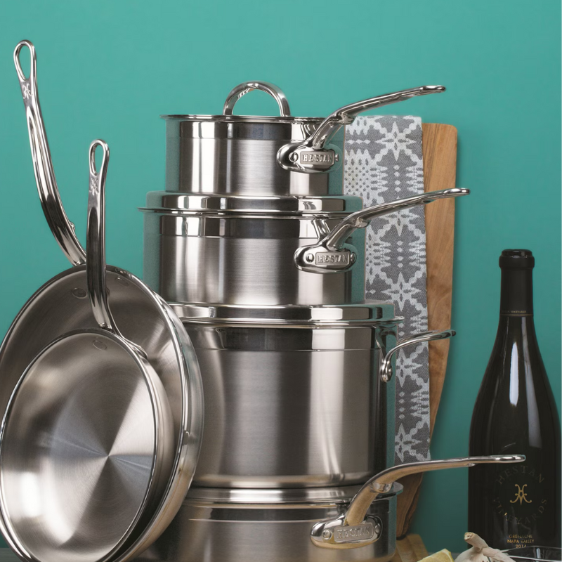 Arrangement of Hestan ProBond Induction Stainless Steel Pan Set: 10 Piece hanging in kitchen on turquoise background