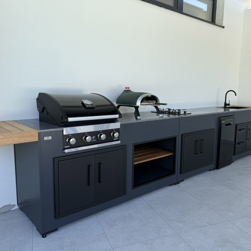Outdoor kitchen with black grill and oven on a tiled patio
