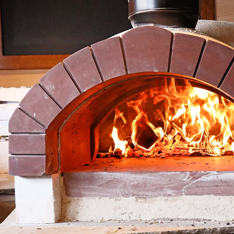 Open door pizza cooking in Igneus Ceramiko Pro 1200 Wood Fired Pizza Oven