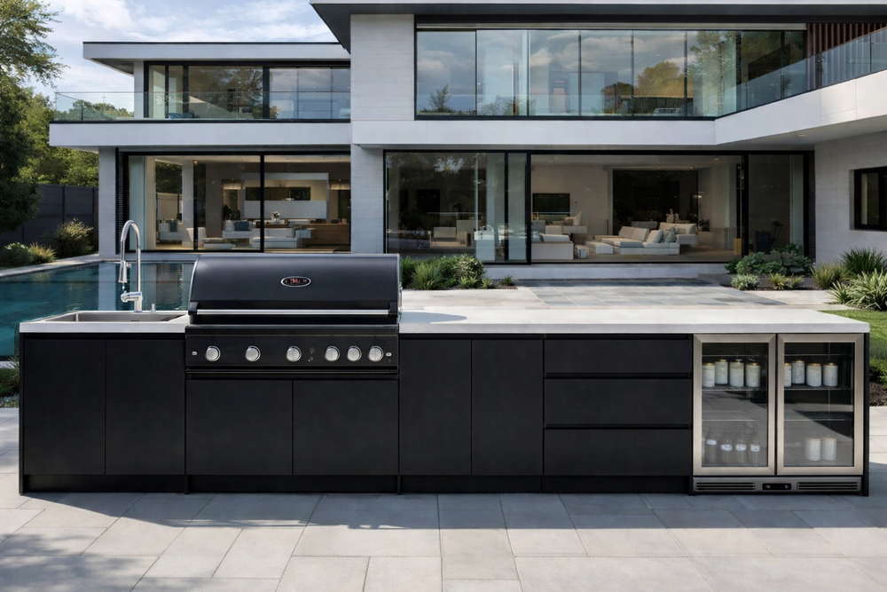 Modern outdoor kitchen with black appliances in a luxurious home setting